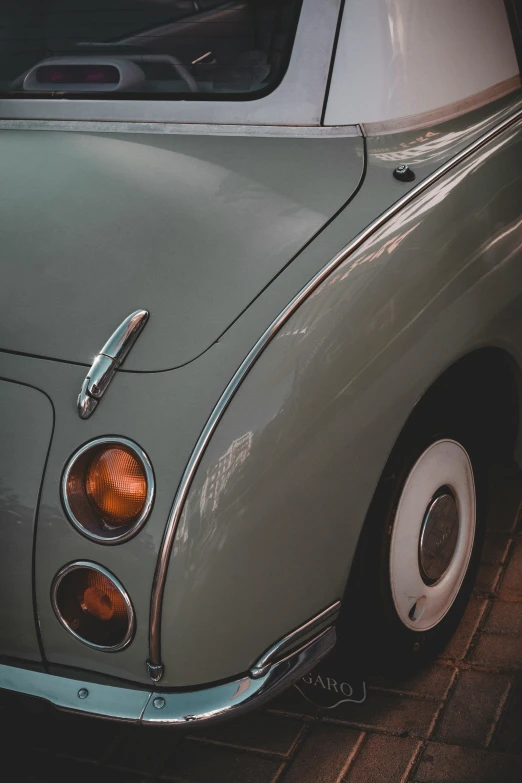 an old vintage volkswagon car sitting on a brick sidewalk