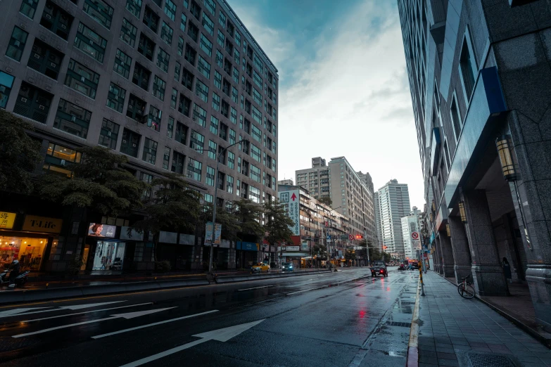 a street in the city with a line of parked cars on the street next to tall buildings