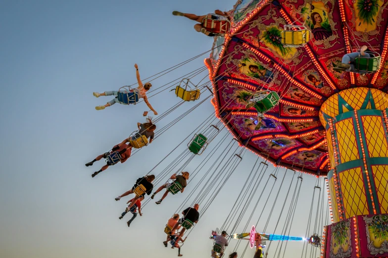 people enjoying the carnival with swings, bars and rides