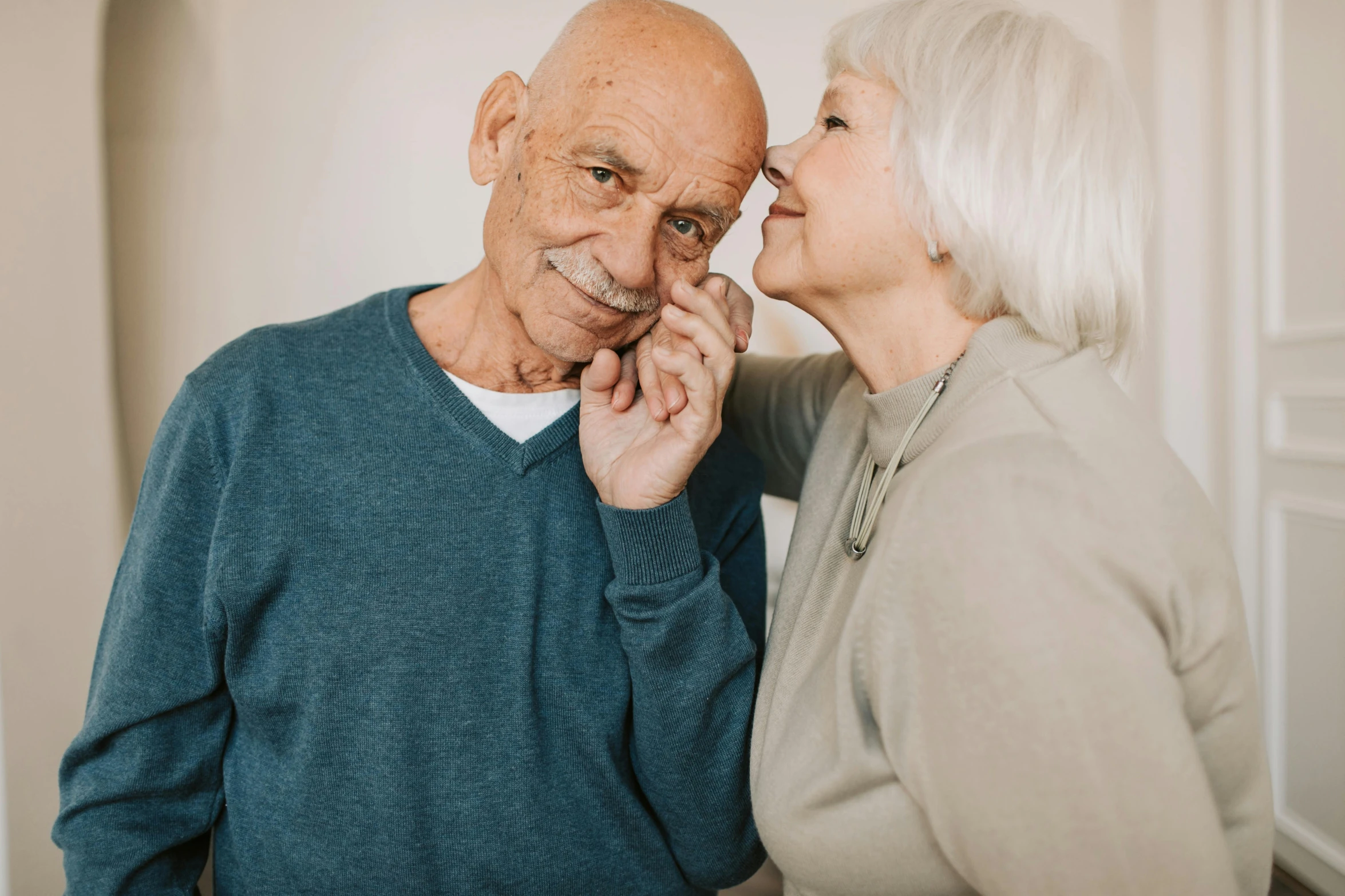 an old man and a woman sharing a loving moment together