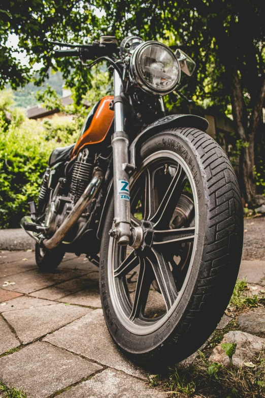 the motor bike is parked on the sidewalk