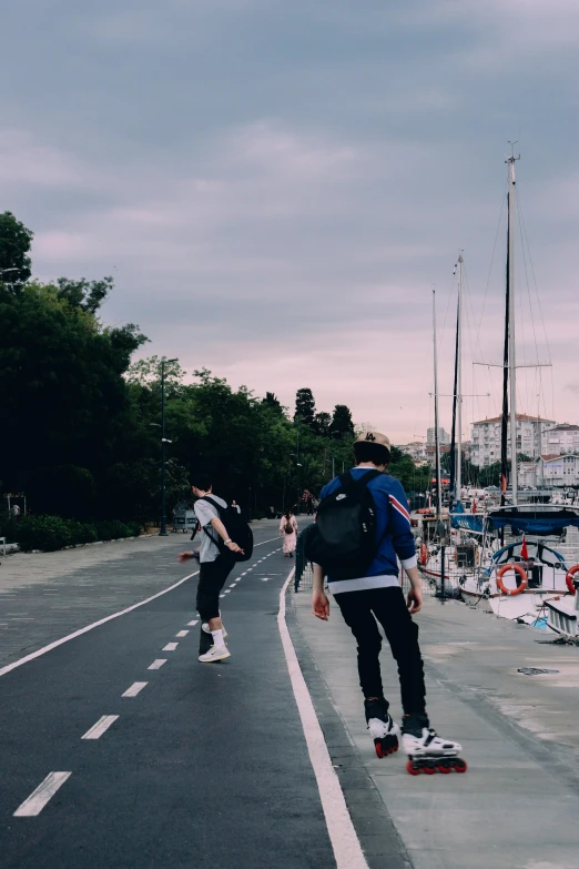 a young man skateboarding down the road as people stand nearby