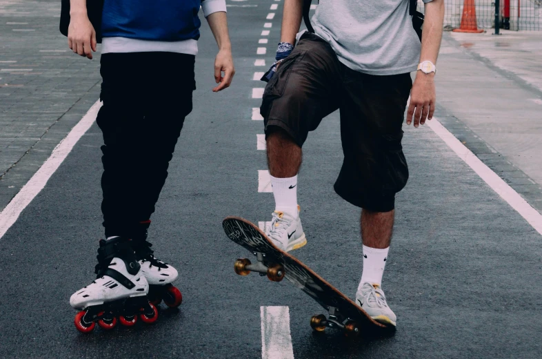 two people walking down the street with skateboards