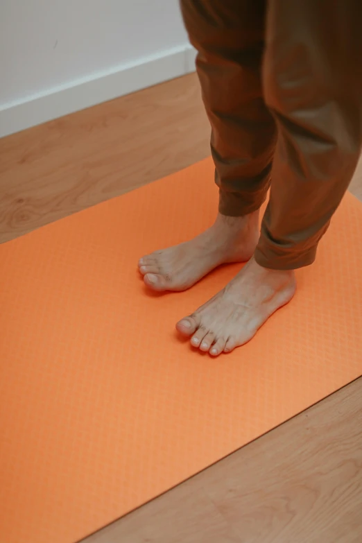a person standing on top of a orange mat
