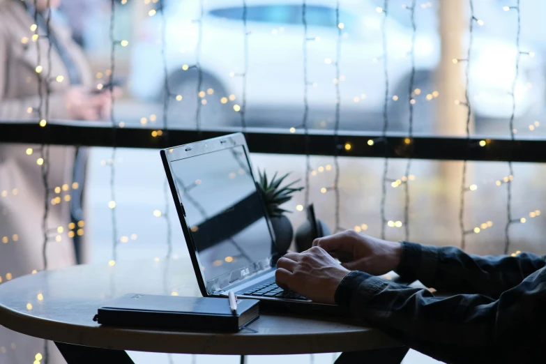 a man sits at a table with his laptop computer