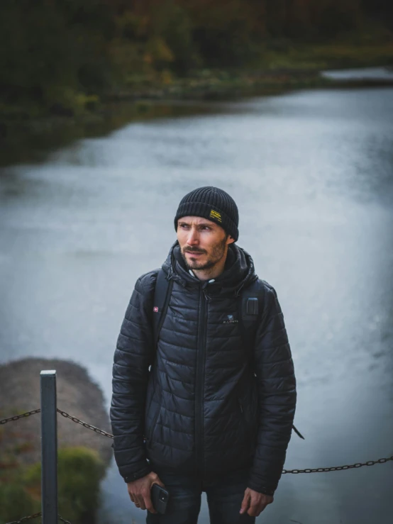 a man standing next to a body of water