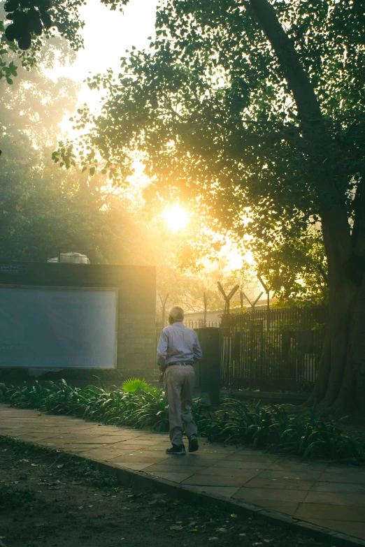 a man walking alone along a path into a movie park at sunset