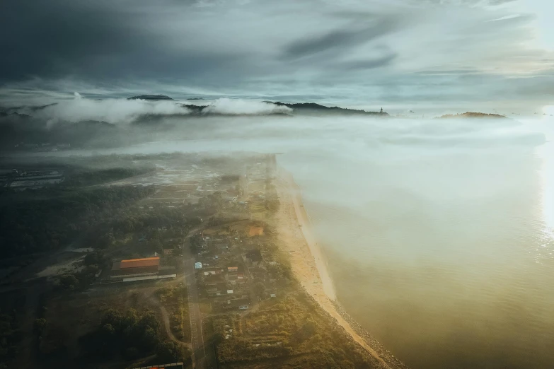 a lake with fog rolling in from it under a dark sky