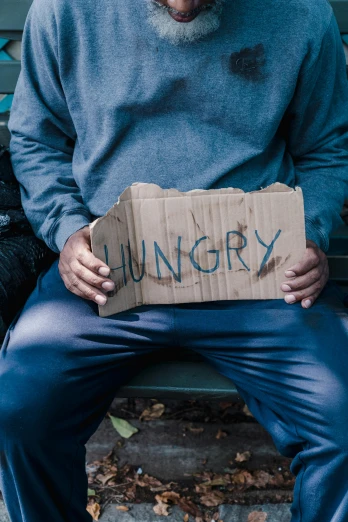 man holding cardboard box with name of hungry on it