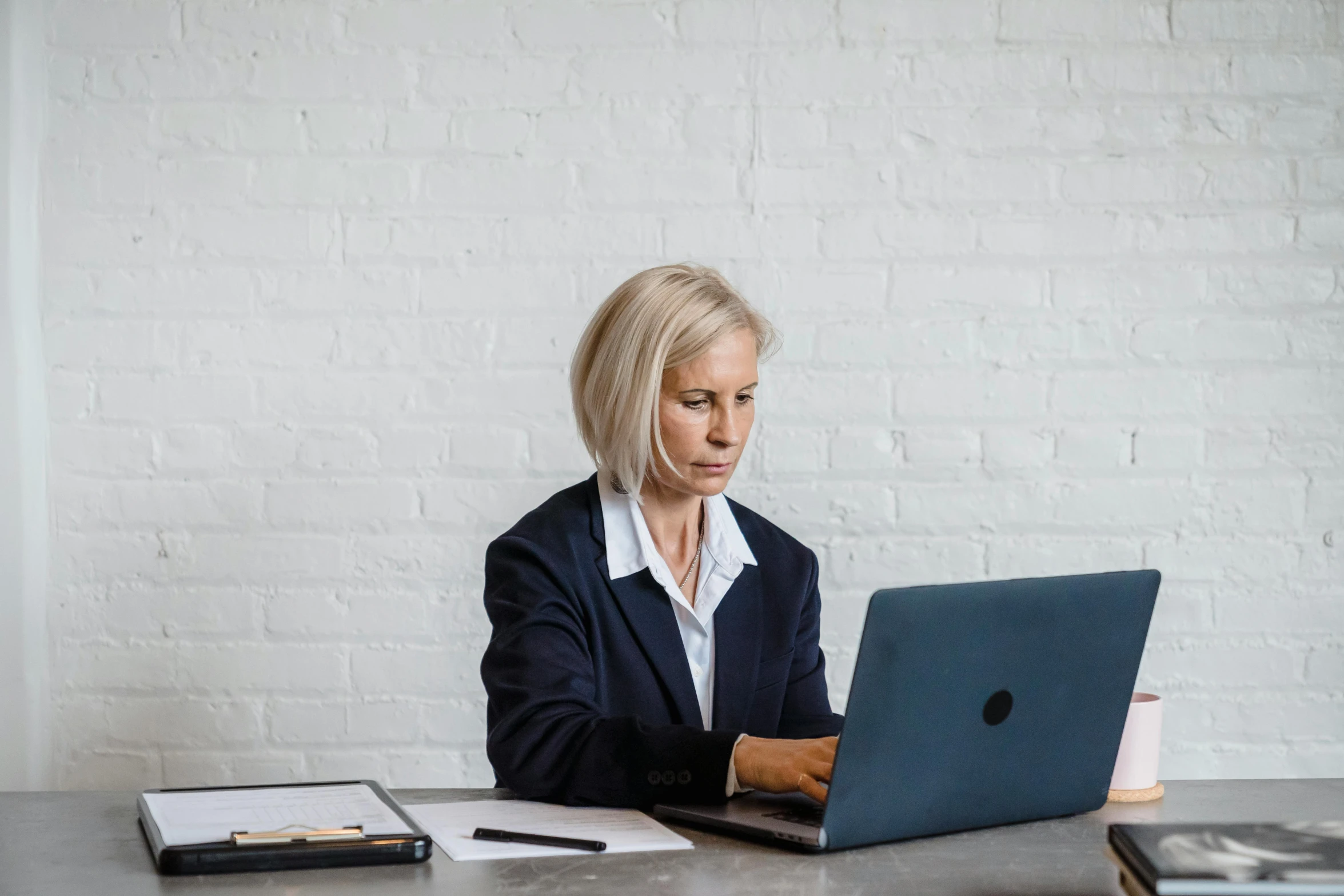 a woman is sitting at a table with a laptop