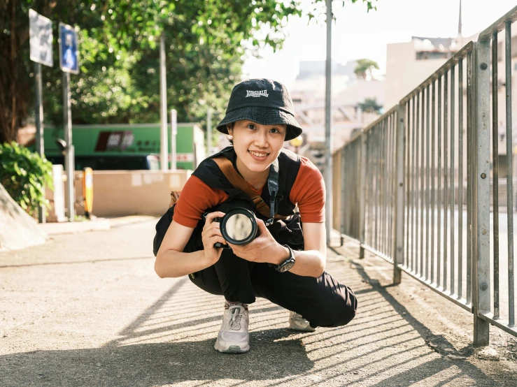 a man kneeling down while holding a camera