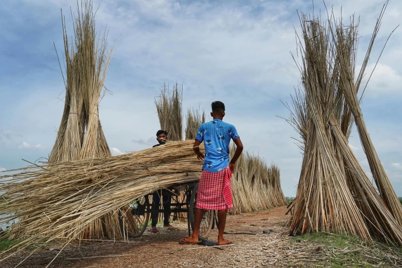 a man standing in front of a pile of sticks