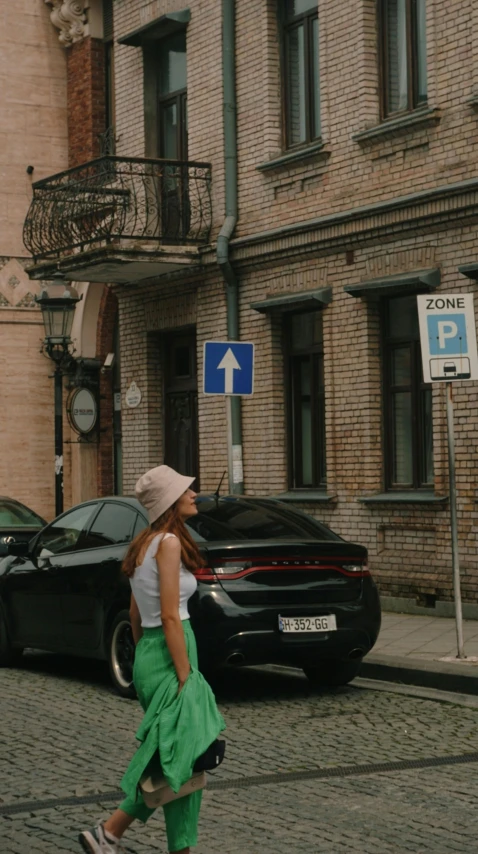 a woman crossing the street in front of a black car