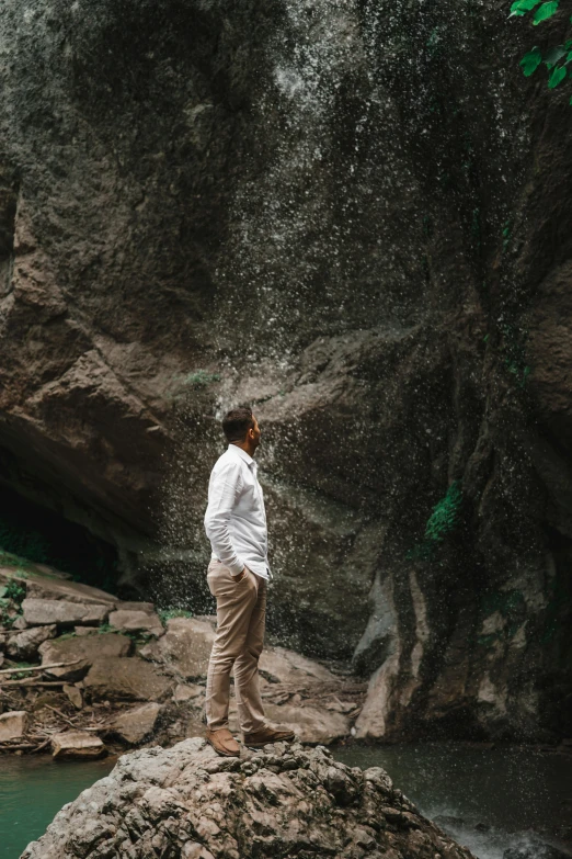 a person standing on top of a rock next to water