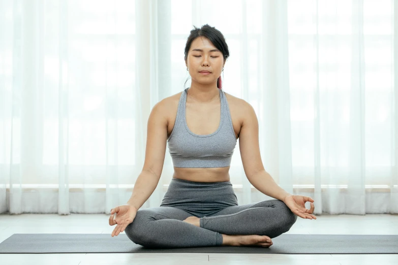 a woman is meditating in a yoga pose