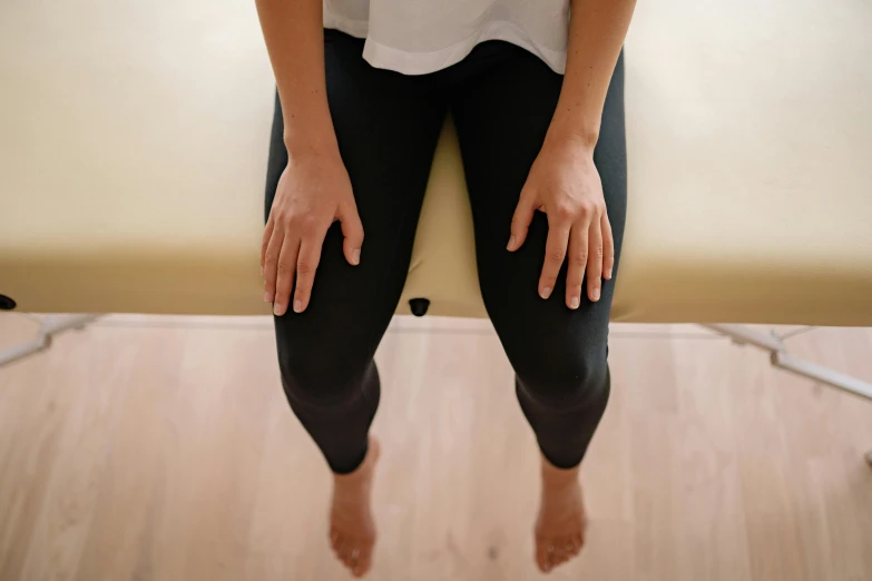 a person sitting in the center of a chair while wearing leggings