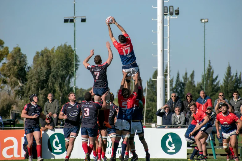 a group of people standing on a field playing rugby