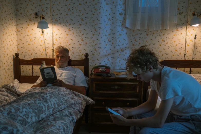 man and woman with tablet computers on a bed in a room