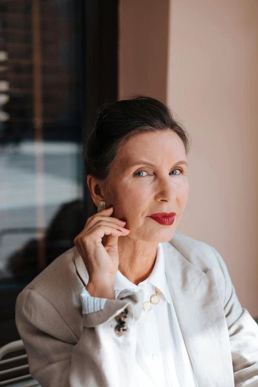 woman in white top and jacket posing for po