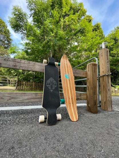 an old skateboard leaning on a wood fence