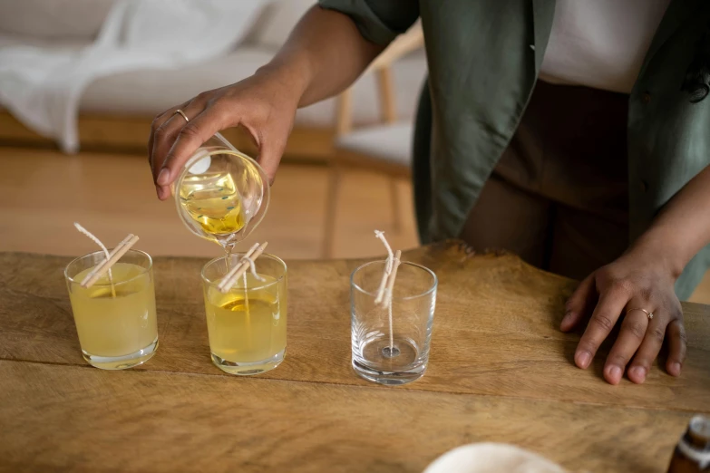 a woman pours some beverage into her s glasses