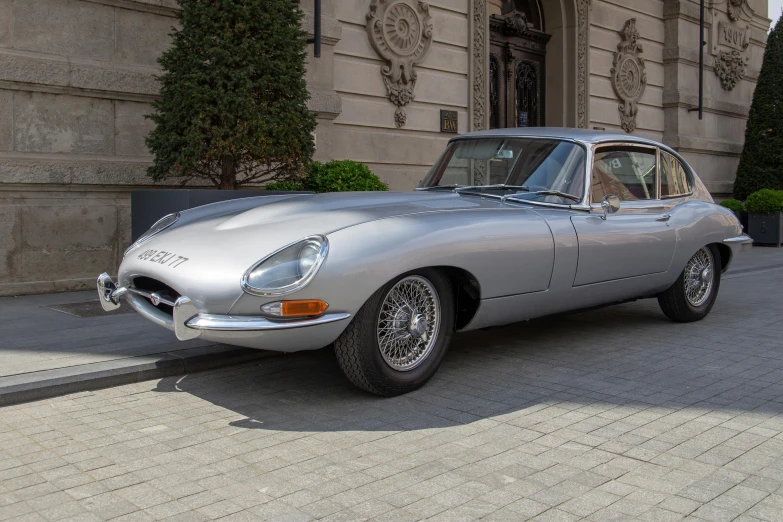 a vintage car parked in front of a large building