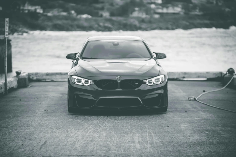 a grey car parked at an industrial gas station near water