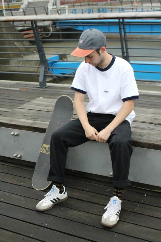 a man sitting down with his skateboard