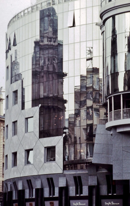 many different buildings are reflected in a glass wall