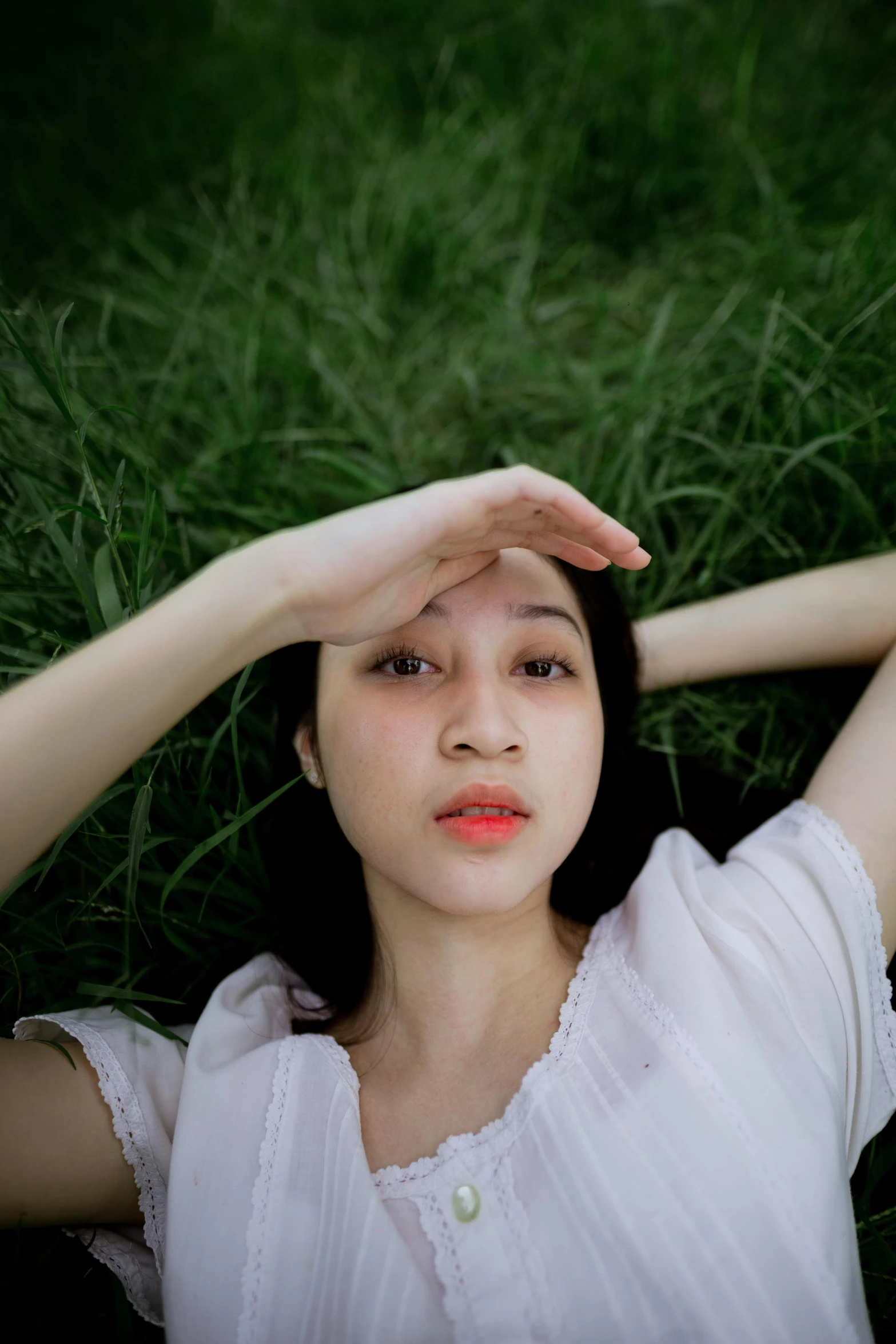 a young woman poses in a field of grass