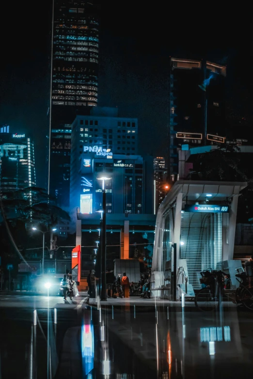 city night with high rise buildings, parked car and lights reflected in water