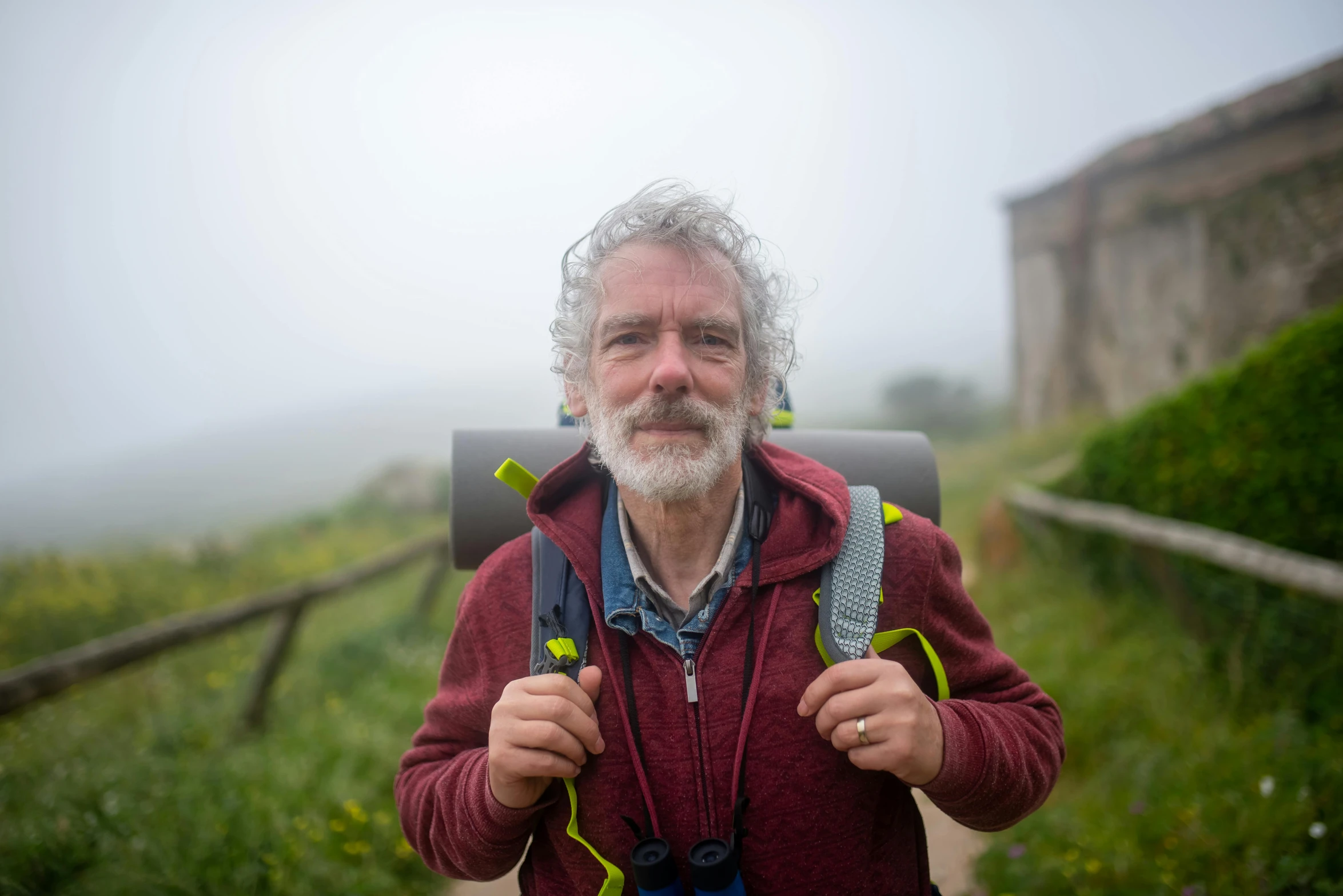 a man in a red jacket with a beard and backpack