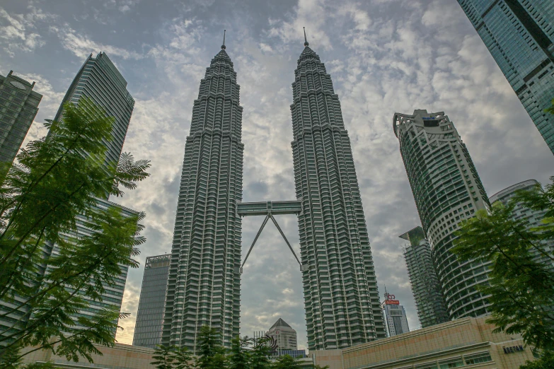 the tall buildings are surrounded by trees and clouds