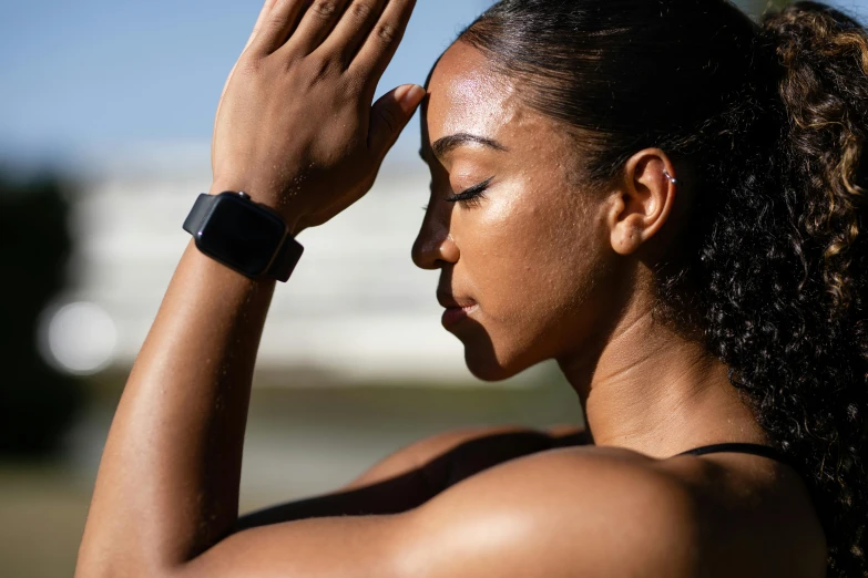 a woman holding her arm to her forehead