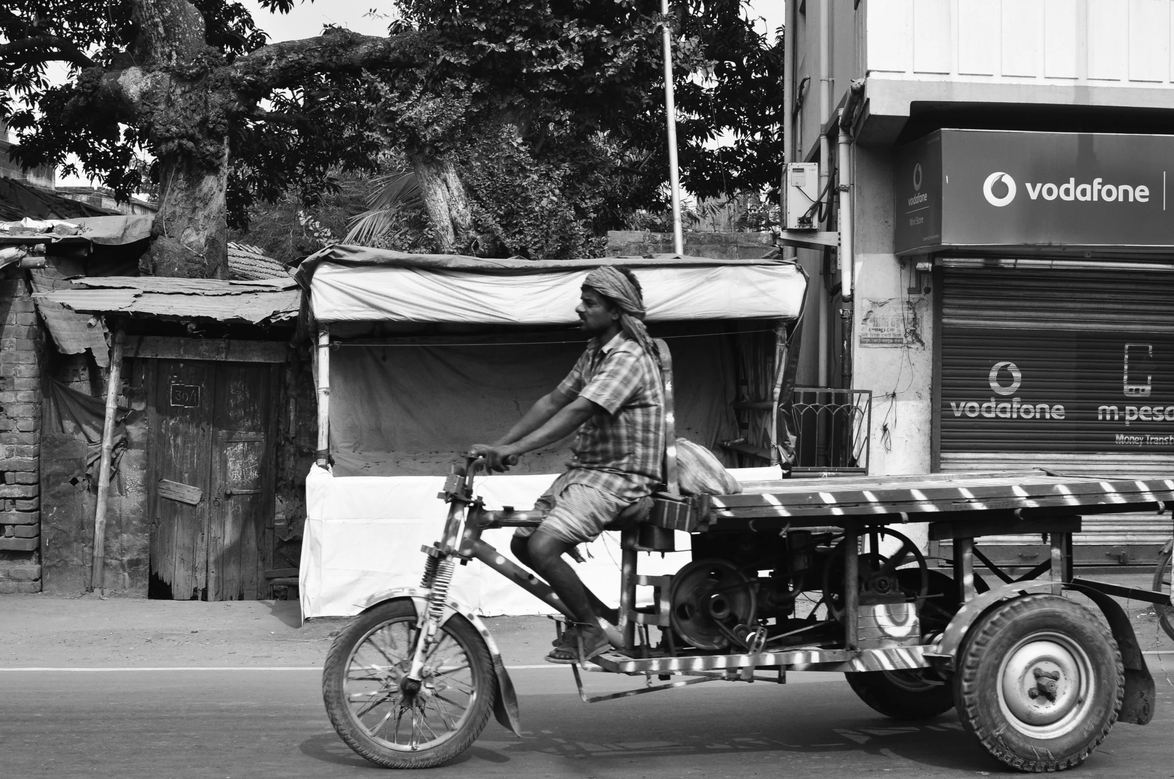 the man is riding the small motorcycle around the town