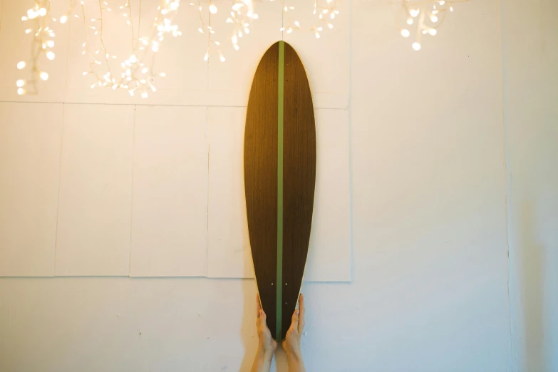 a surfboard hanging on the wall above two other pieces of wood