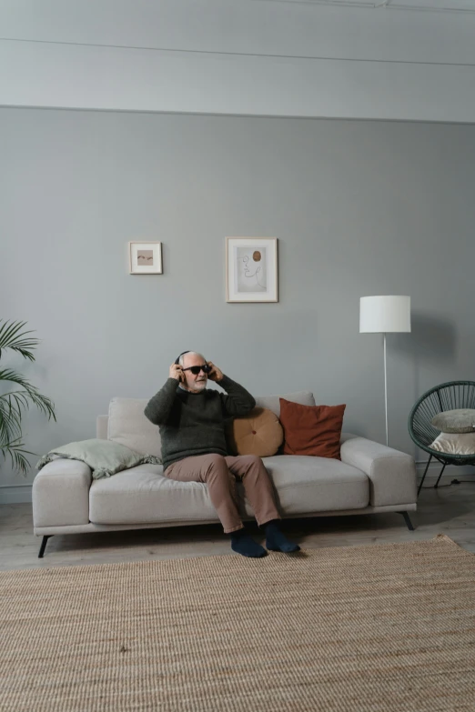 a man is sitting on the couch taking a po