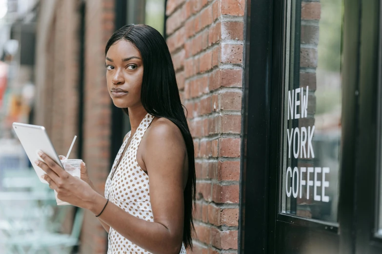 a woman standing outside a cafe on a tablet