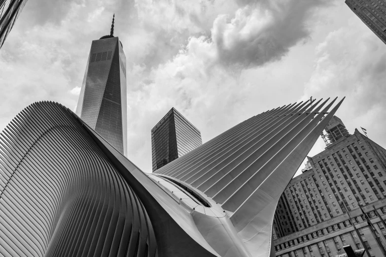 a tall building surrounded by other buildings under a cloudy sky