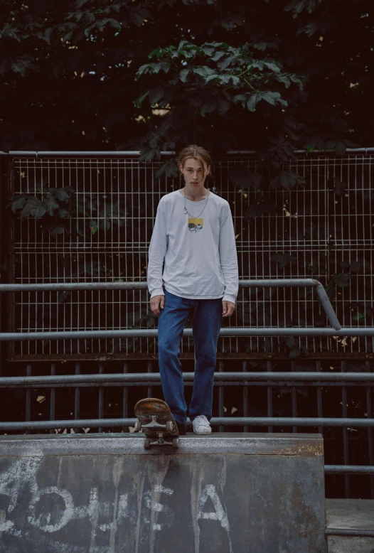 a young man is standing on top of a ramp with his skateboard