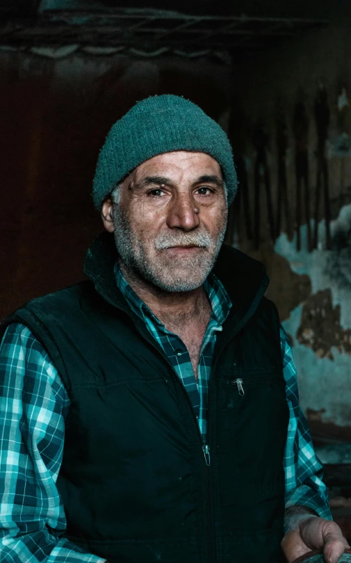 a close up of a man wearing a hat and a vest