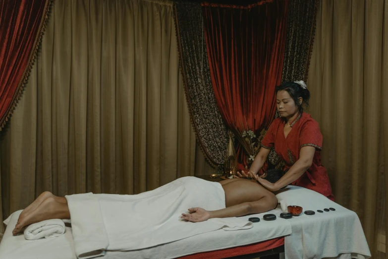 a woman laying on a table next to a man in a white towel