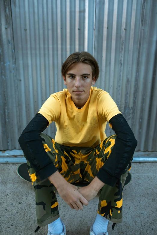 a man wearing camouflage pants poses for the camera