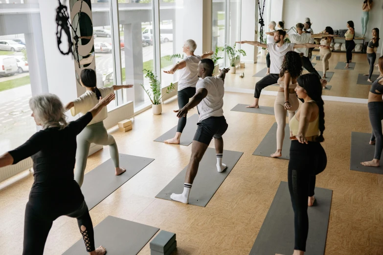 people are doing yoga on mat in a large room