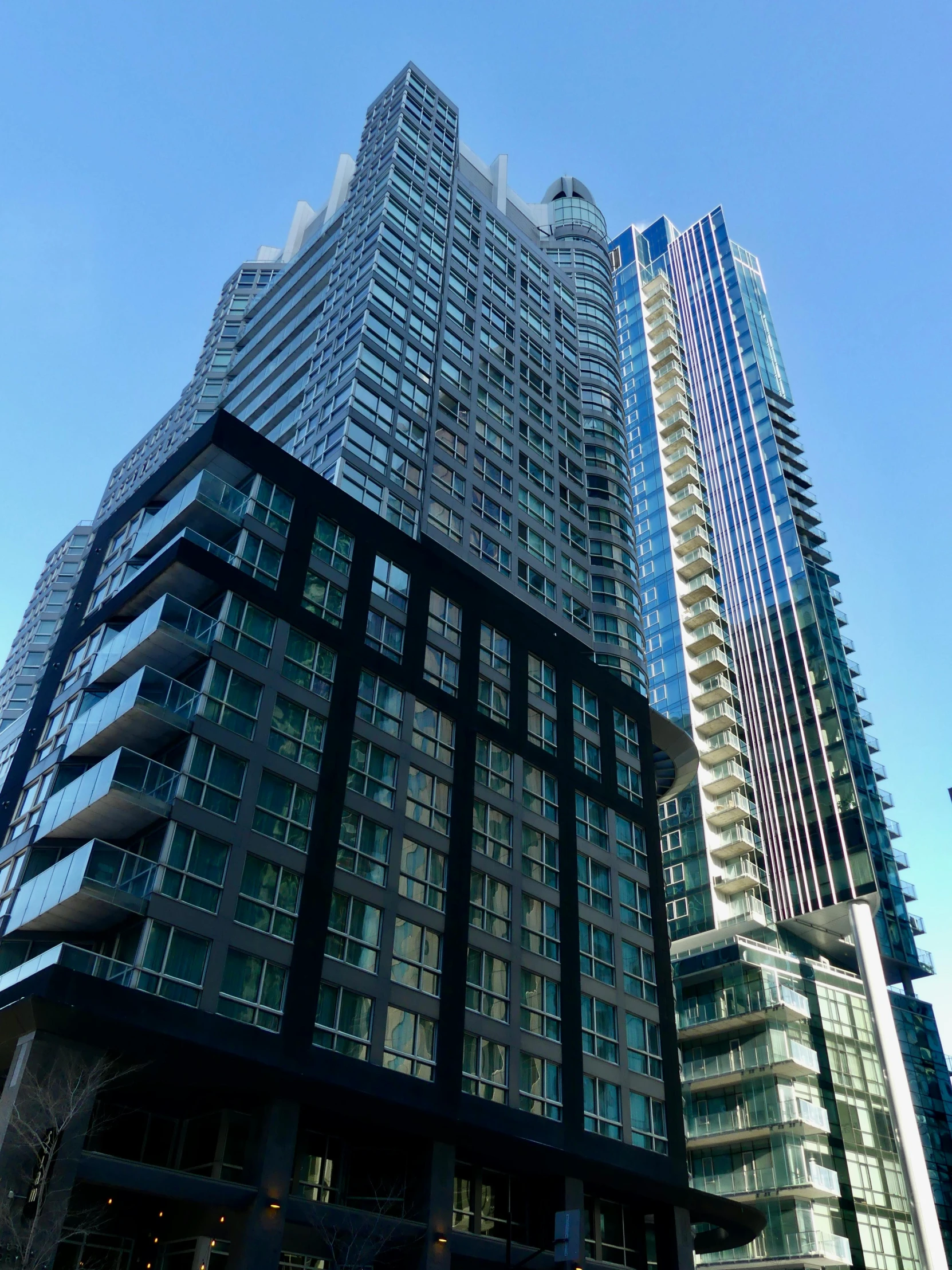 two tall buildings side by side in front of blue sky