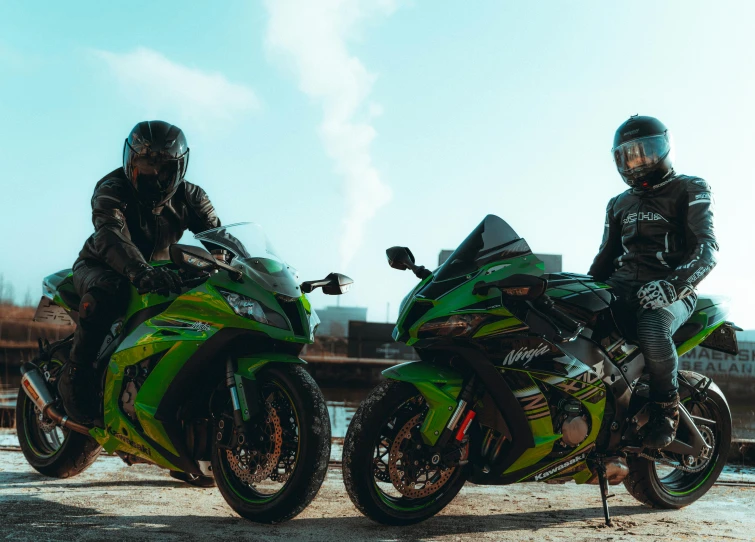 two people on a motorcycle one has a helmet and the other is green