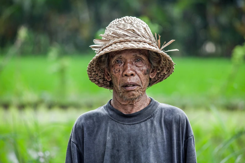 a woman with an old hat is standing in a field