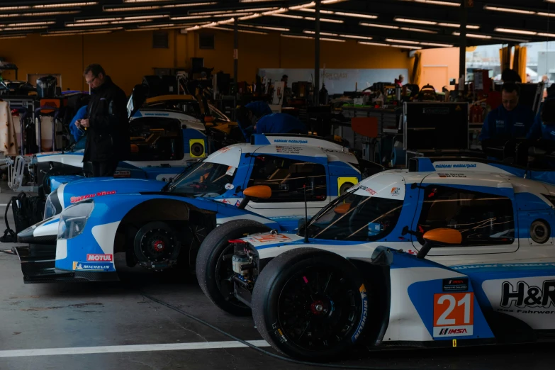 a car sits parked in a garage with other cars behind it