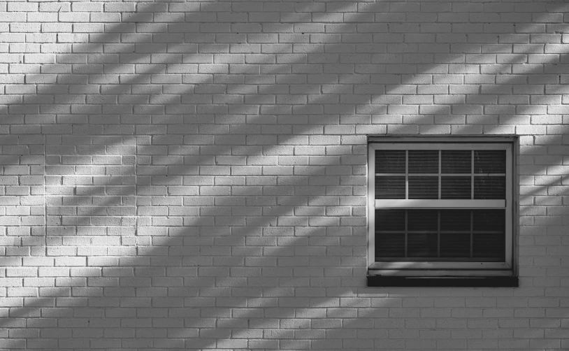 black and white pograph of the shadow on a brick wall