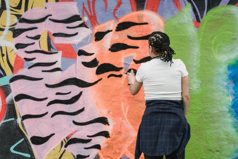 a woman standing in front of a colorful wall